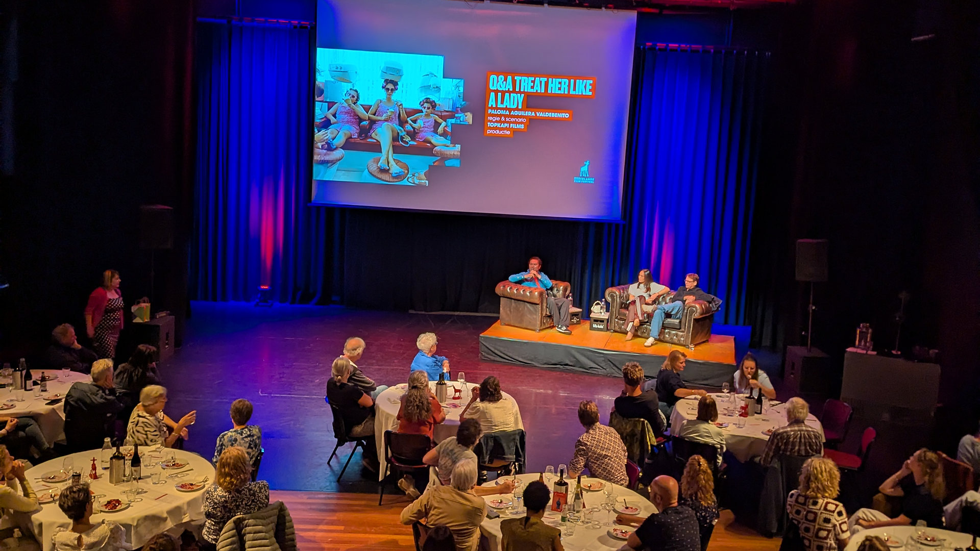 Evenement met diner en een gesprek op het podium