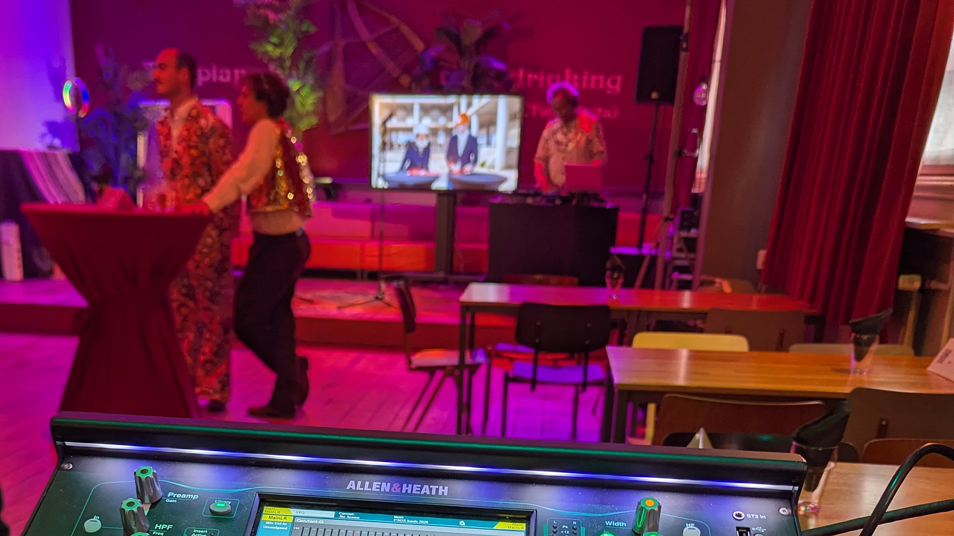 Feestzaal met dansende gasten, gezien vanaf de mengtafel