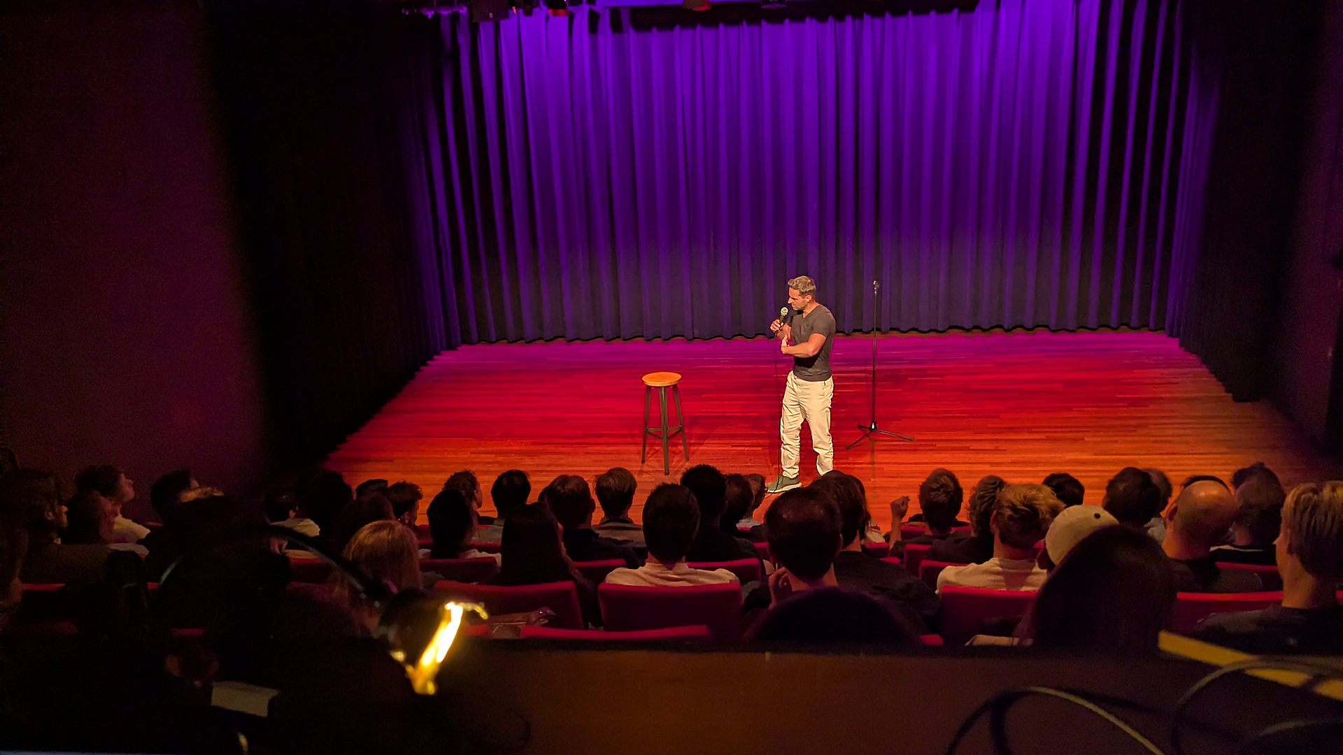 Cabaretier op een theaterpodium, gezien vanaf de lichttafel
